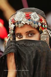 Image du Maroc Professionnelle de  Une jeune fille du désert pose en tenue traditionnelle durant le grand Moussem de Tan Tan. Ce grand rassemblement est organisé dans un site désertique sur lequel la ville de Tan Tan a toujours accueilli la majorité des tribus et des grandes familles nomades du désert lors d'un grand moussem, Samedi 18 septembre 2004. (Photo / Abdeljalil Bounhar)




